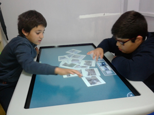 Alumnos trabajando en la mesa multitáctil