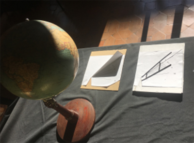 Exposición sobre el reloj de sol realizada en el IES San Isidro: Relojes de sol de papel realizados por alumnos y globo terráqueo antiguo